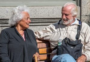 senior couple outdoors sitting on a bench