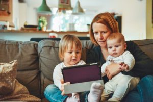 woman sitting on a couch with two babies