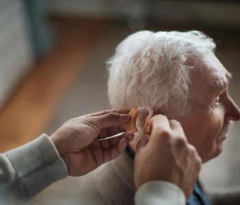 senior man getting fitted for hearing aid