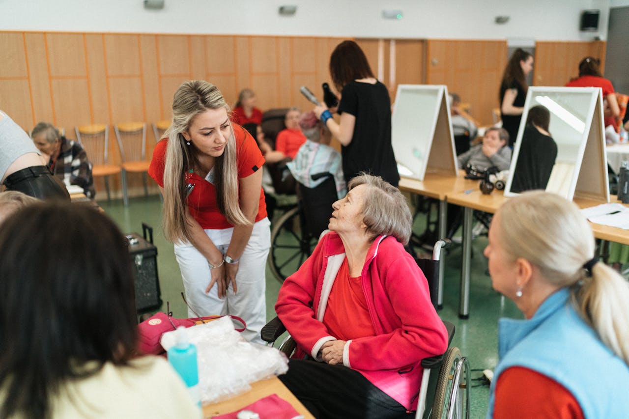 caregiver talking to elderly woman in wheelchair